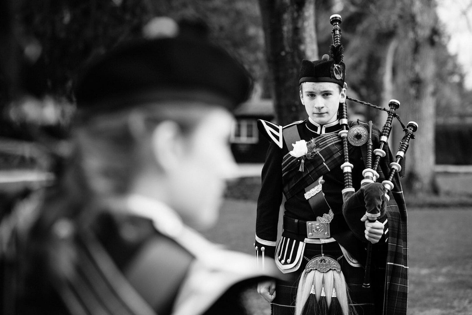 Larmertree garden wedding 54 Bagpiper stands to attention