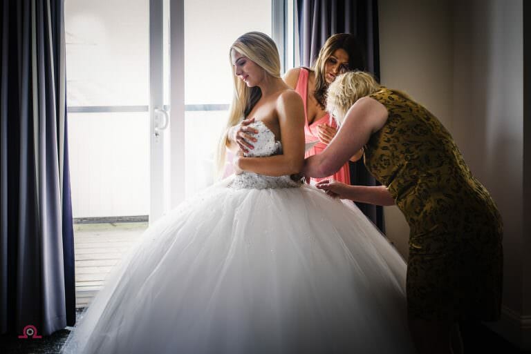 Bride puts on her wedding dress at the Sandbanks Hotel