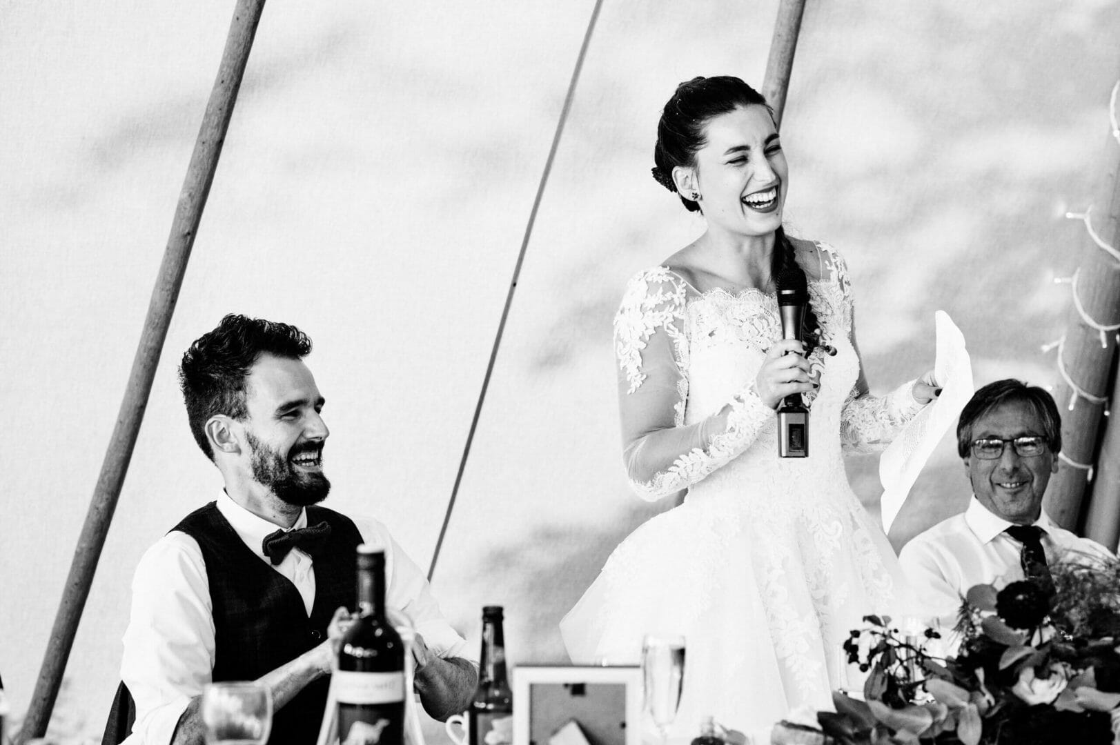 Bride stands for speech at Tipi wedding