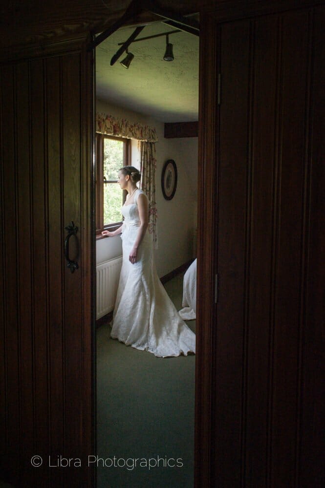 Bride gazes out of window