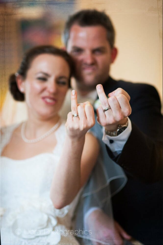 Bride and groom sticking up ring fingers