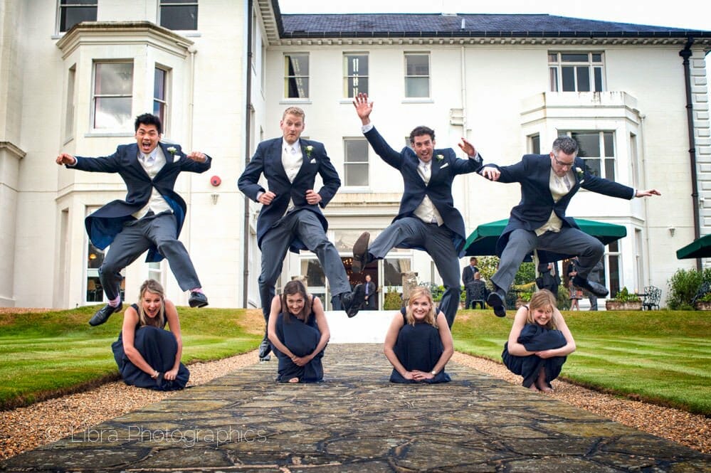 Groomsmen jump over the brides