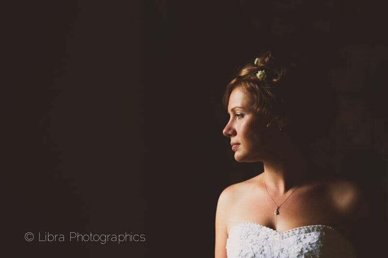 Bride looks from a window at Old wardour castle