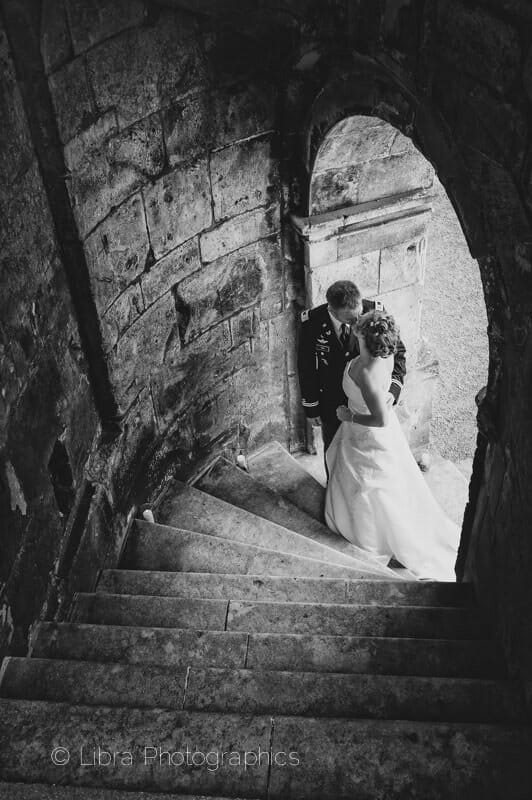 Bride and Groom pose on the steps of old Wardour Castle