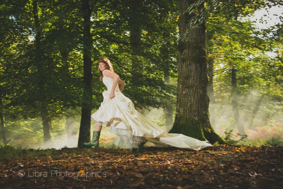 Bride running through New forest