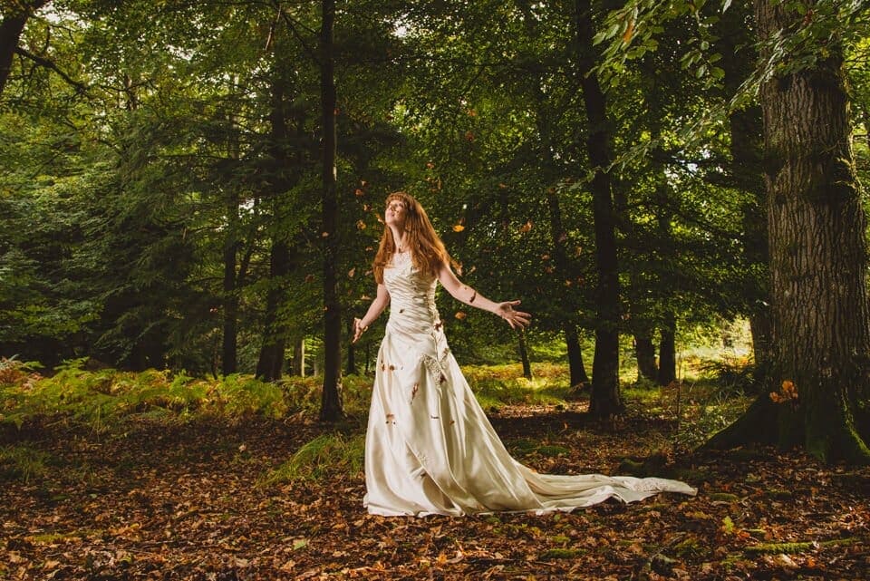 Bride throwing autumn leaves in the air